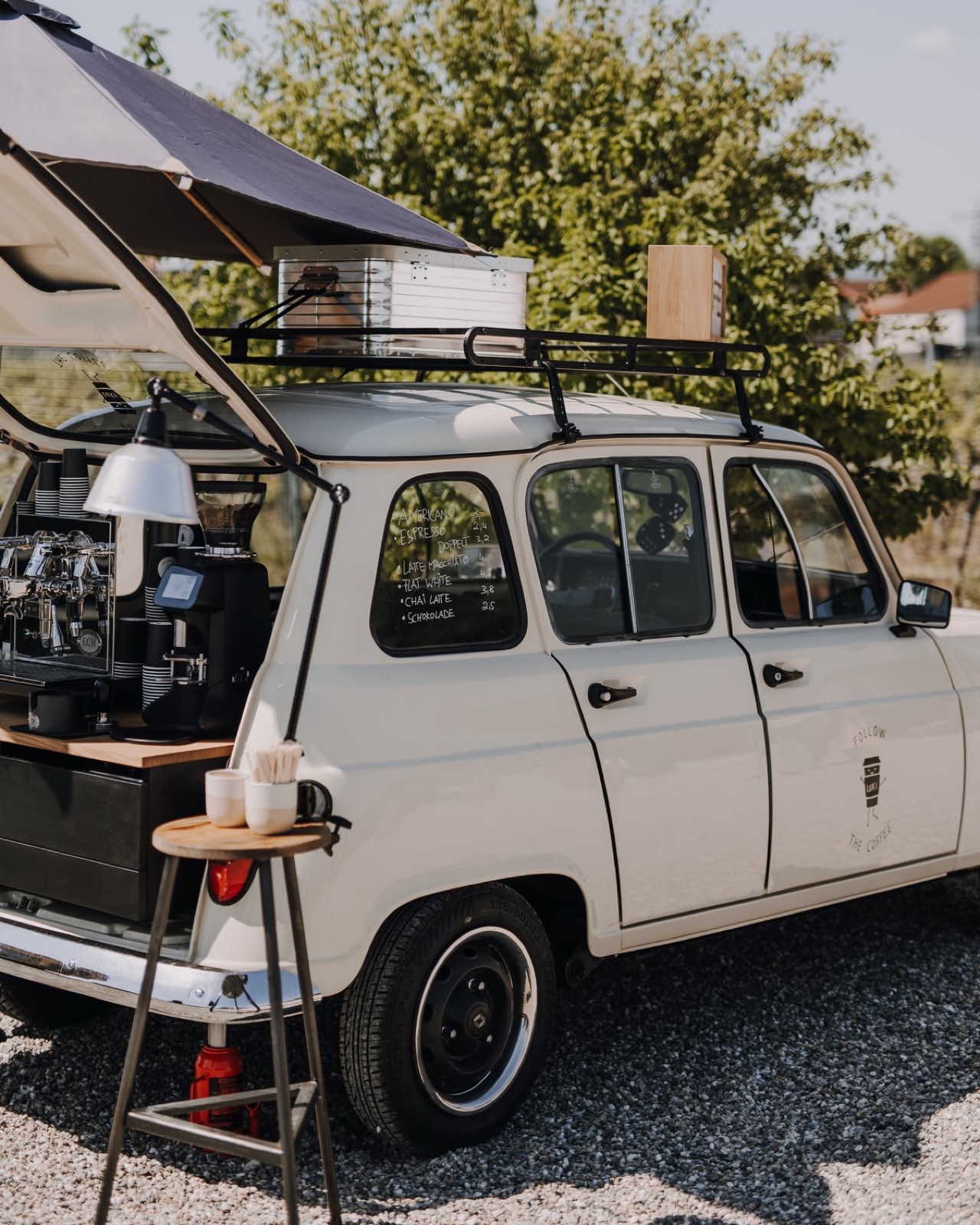 White vintage compact car configured as a mobile espresso bar
