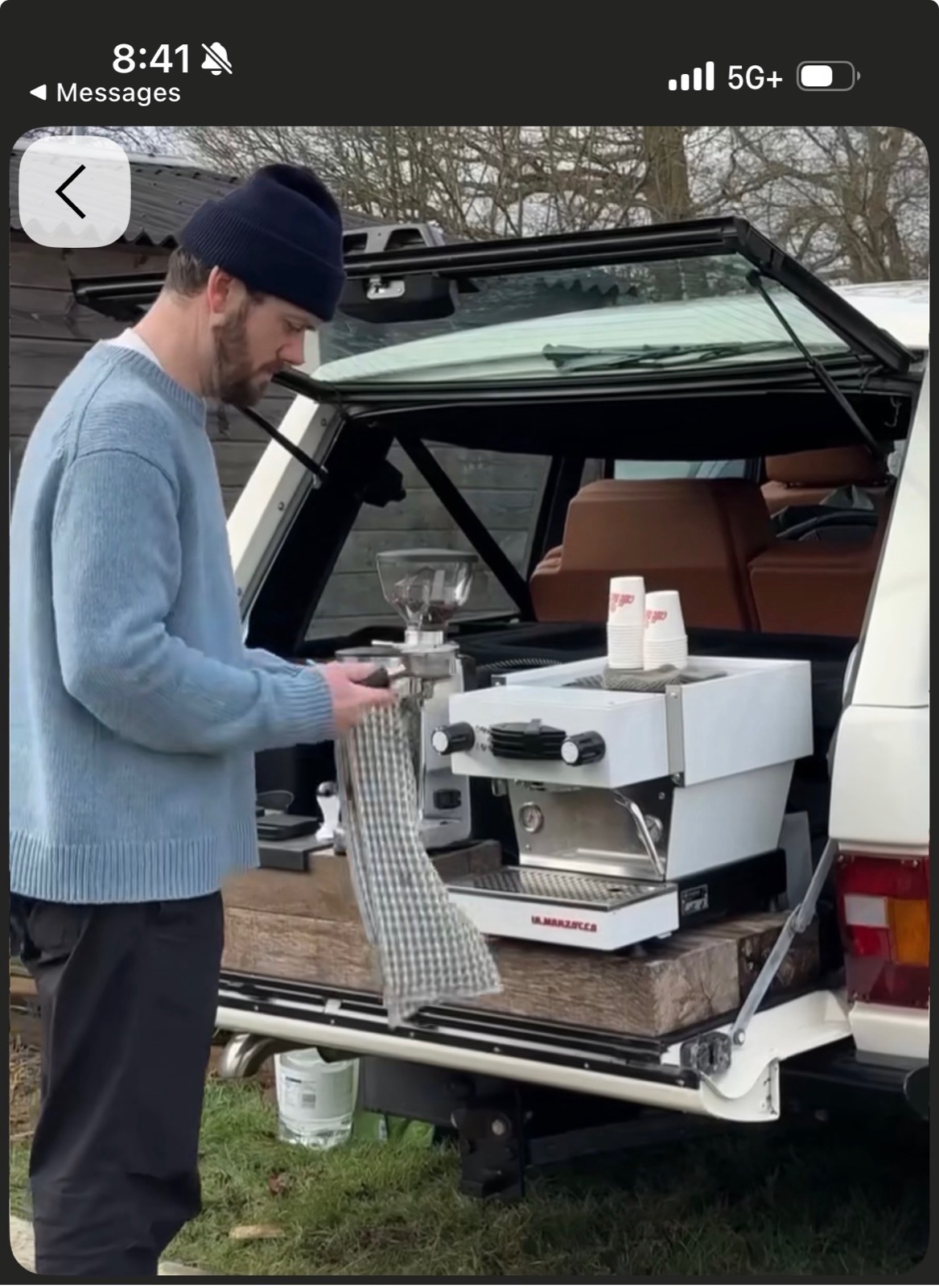 Barista preparing coffee from a vehicle-mounted espresso bar